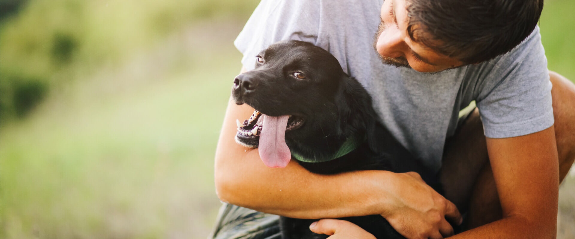 Mann mit schwarzem Hund in den Armen